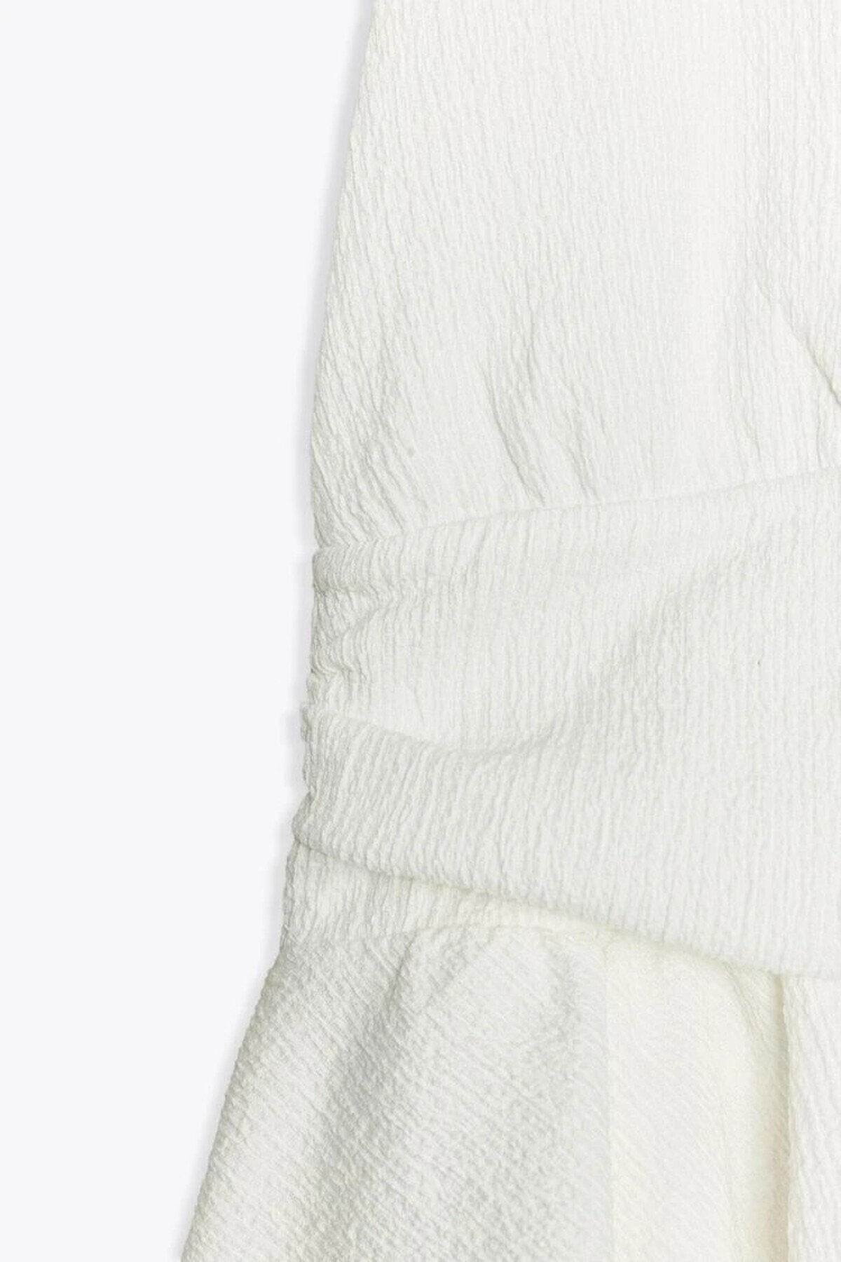 KADIN V YAKA SIRTI AÇIK DOKULU KUMAŞ ETEĞİ VOLANLI BLUZ